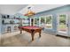 The basement billiards room provides access to the exterior with decor shelving and natural light at 4020 Devereux Chase, Roswell, GA 30075
