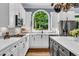 Bright kitchen featuring white cabinets, stainless steel appliances, and a large arched window at 4020 Devereux Chase, Roswell, GA 30075