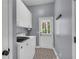 Functional laundry room with washer, dryer, storage cabinets, and convenient access to the outdoors at 4020 Devereux Chase, Roswell, GA 30075