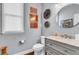 Stylish powder room with modern fixtures, decorative art, and a gray vanity at 4020 Devereux Chase, Roswell, GA 30075