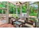 A lovely screened porch features brick floors, comfortable wicker seating, and views of the lush backyard at 4020 Devereux Chase, Roswell, GA 30075