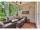 Inviting screened porch with brick flooring and comfortable seating, perfect for relaxing and enjoying the outdoors at 4020 Devereux Chase, Roswell, GA 30075