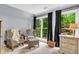 A comfy sitting area features plush seating with serene views through bright windows with dark curtains at 4020 Devereux Chase, Roswell, GA 30075