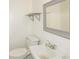 Modest bathroom featuring white fixtures, a gray framed mirror and floating shelf at 2325 E Hill Way, Norcross, GA 30071