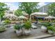Picturesque outdoor courtyard with umbrella-covered tables, lush planters, and comfortable seating at 250 Pharr Ne Rd # 1814, Atlanta, GA 30305