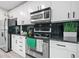 Bright kitchen featuring white cabinetry, stainless steel appliances, black countertops and black tile backsplash at 250 Pharr Ne Rd # 1814, Atlanta, GA 30305