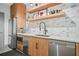 Modern kitchenette with stainless steel appliances, sleek countertops, and floating shelves for stylish storage at 250 Pharr Ne Rd # 1814, Atlanta, GA 30305
