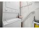Bright laundry room featuring a stacked washer and dryer, with organizational racks and cleaning supplies conveniently arranged at 250 Pharr Ne Rd # 1814, Atlanta, GA 30305