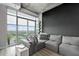 Modern living room with large windows offering stunning city views, stylish grey sofa, and sleek decor at 250 Pharr Ne Rd # 1814, Atlanta, GA 30305
