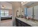 Bathroom featuring double sinks, granite countertops, modern fixtures, and an entrance to the bedroom at 4708 Tiger Blvd, Duluth, GA 30096
