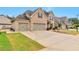 Beautiful brick home with a three-car garage and well-manicured lawn and front yard at 4708 Tiger Blvd, Duluth, GA 30096
