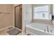 A bathroom featuring a glass shower, a tub, and a window allowing natural light at 4708 Tiger Blvd, Duluth, GA 30096
