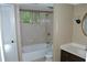Bathroom with a tub shower combination with shower rod and tan tiled walls, commode and vanity at 1159 Aurora Ct, Atlanta, GA 30338