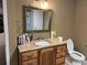 Bathroom featuring a wooden vanity with granite top and decorative mirror with updated lighting at 1159 Aurora Ct, Atlanta, GA 30338