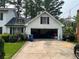 Detached garage with ample driveway space and basketball hoop above with black shutters and white painted brick at 1159 Aurora Ct, Atlanta, GA 30338