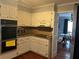 Functional kitchen with white cabinets, tile countertops, and a view into the adjacent dining room at 1159 Aurora Ct, Atlanta, GA 30338