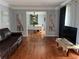 Cozy living room with hardwood floors, comfortable leather sofa, and open doorway to the dining room at 1159 Aurora Ct, Atlanta, GA 30338
