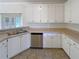 Well-lit kitchen boasts stainless steel dishwasher, sleek white cabinets and a functional layout at 132 Lynnview Ct, Mcdonough, GA 30252