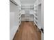 Large organized walk-in closet with white shelves and dark hardwood floors at 2751 Camp Branch Rd, Buford, GA 30519