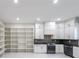 An open kitchen area featuring white cabinetry, stainless steel appliances, and a large shelving unit at 2751 Camp Branch Rd, Buford, GA 30519