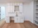 Stylish mini bar featuring white cabinets, marble countertop, wine rack and hardwood floors at 2751 Camp Branch Rd, Buford, GA 30519