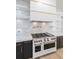 Close up of a range, marble back splash, and floating shelves at 2751 Camp Branch Rd, Buford, GA 30519