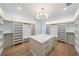 Large walk-in closet with custom storage, central island, shelving, and hardwood floors at 2751 Camp Branch Rd, Buford, GA 30519