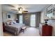 Comfortable bedroom with a ceiling fan, two windows, neutral carpet, and warm lighting at 2884 Overwood Ln, Snellville, GA 30078