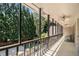Long, tiled balcony featuring dark railings, ceiling fans, and overlooking a lush, green landscape at 1935 Northbrooke Ln, Dunwoody, GA 30338