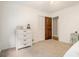 A cozy bedroom with neutral carpet, white trim, and a natural wood door at 1935 Northbrooke Ln, Dunwoody, GA 30338