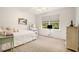 Bright bedroom featuring white walls, carpeted floors, and a window overlooking lush greenery at 1935 Northbrooke Ln, Dunwoody, GA 30338
