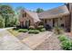 Brick home's entryway with a concrete walkway, manicured bushes, and Adirondack chairs on a porch at 1935 Northbrooke Ln, Dunwoody, GA 30338