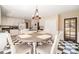 Bright eat-in kitchen with white cabinets, black countertops, checkerboard floors, and dining table at 1935 Northbrooke Ln, Dunwoody, GA 30338