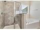 Luxurious bathroom featuring a tiled walk-in shower and separate soaking tub next to a bright window at 1955 Overlook Run Pl, Cumming, GA 30040