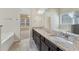 Bright bathroom with granite countertops, double vanity, and large mirror reflecting the soaking tub at 1955 Overlook Run Pl, Cumming, GA 30040