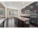 Modern kitchen with granite countertops, stainless appliances, and dark wood cabinets at 1955 Overlook Run Pl, Cumming, GA 30040