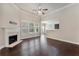 Comfortable living room featuring hardwood floors, a fireplace, and partial open kitchen view at 1955 Overlook Run Pl, Cumming, GA 30040