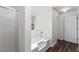 Bathroom with a white tub and shower, vinyl wood flooring, and natural light, creating a clean and relaxing space at 3448 Craggy Perch, Douglasville, GA 30135