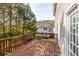 Wooden deck overlooking lush trees, offering a serene outdoor space, and a white house in background at 3448 Craggy Perch, Douglasville, GA 30135