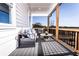 Relaxing covered back porch with a dark gray seating and tree-lined vista beyond at 4720 Montane St, Cumming, GA 30028