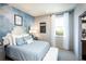 Bedroom featuring a watercolor accent wall, plush blue bedding, and hardwood floors at 4720 Montane St, Cumming, GA 30028
