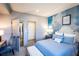 Bedroom boasts beautiful cloud mural, adjacent bathroom, walk-in closet and blue upholstered chair at 4720 Montane St, Cumming, GA 30028