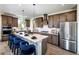 Modern kitchen with stainless steel appliances, a large island with bar seating, and stylish pendant lighting at 4720 Montane St, Cumming, GA 30028