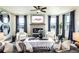 Open living room with fireplace, ceiling fan, and large windows with custom window treatments at 4720 Montane St, Cumming, GA 30028