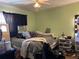 A cozy bedroom includes a ceiling fan, window AC unit, and natural light creating a comfortable space at 5317 Kings Hwy, Douglasville, GA 30135