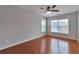 Cozy bedroom featuring hardwood floors, ceiling fan, and bright windows at 5613 Lancashire Ln, Cumming, GA 30041