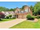 Attractive home showcasing a well-kept lawn, mature trees, and a convenient three-car garage at 5613 Lancashire Ln, Cumming, GA 30041