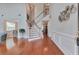 The two-story foyer features hardwood floors, a staircase, and abundant natural light at 5613 Lancashire Ln, Cumming, GA 30041