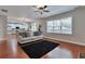 Open concept living room with hardwood floors, a modern sofa, and view into the kitchen at 5613 Lancashire Ln, Cumming, GA 30041