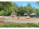 A charming playground area with slides, swings, and a whimsical roundabout, set in a community with mature trees at 5613 Lancashire Ln, Cumming, GA 30041